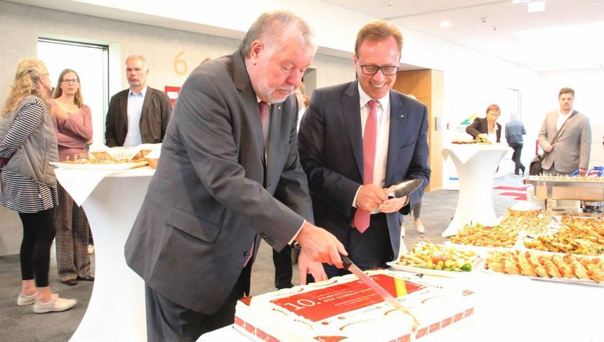 Ex-Ministerpräsident Kurt Beck (l.) und Verbandspräsident Ralph Schlusche schneiden den Geburtstagskuchen an.